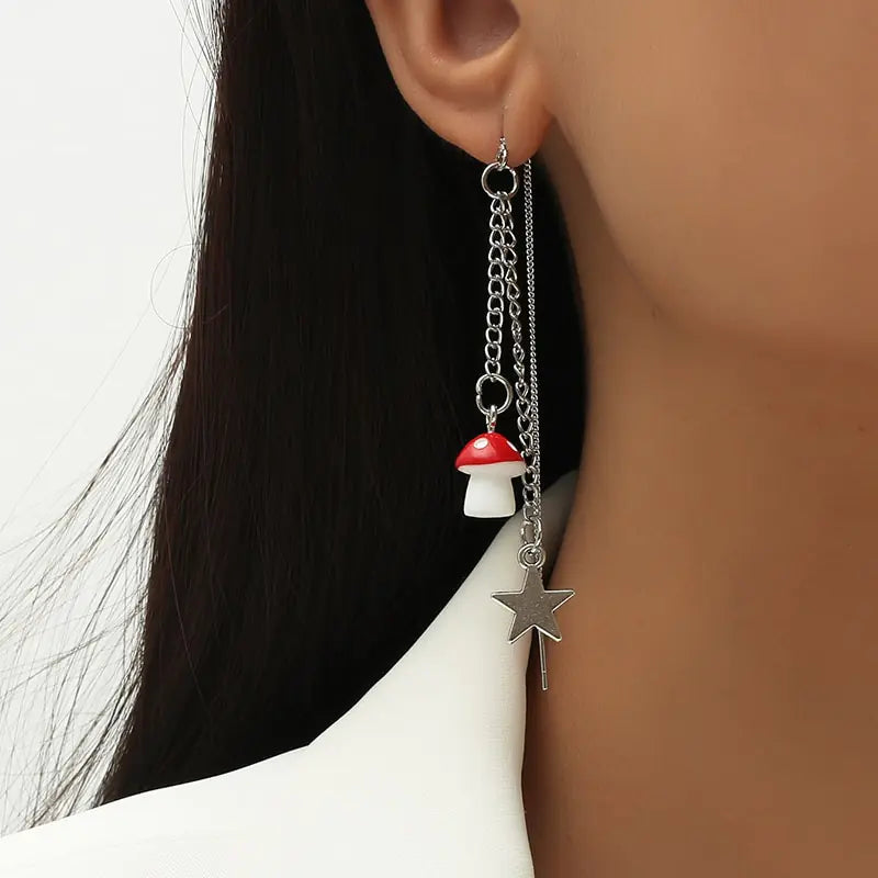 Earring with mushroom and star charms worn by a person