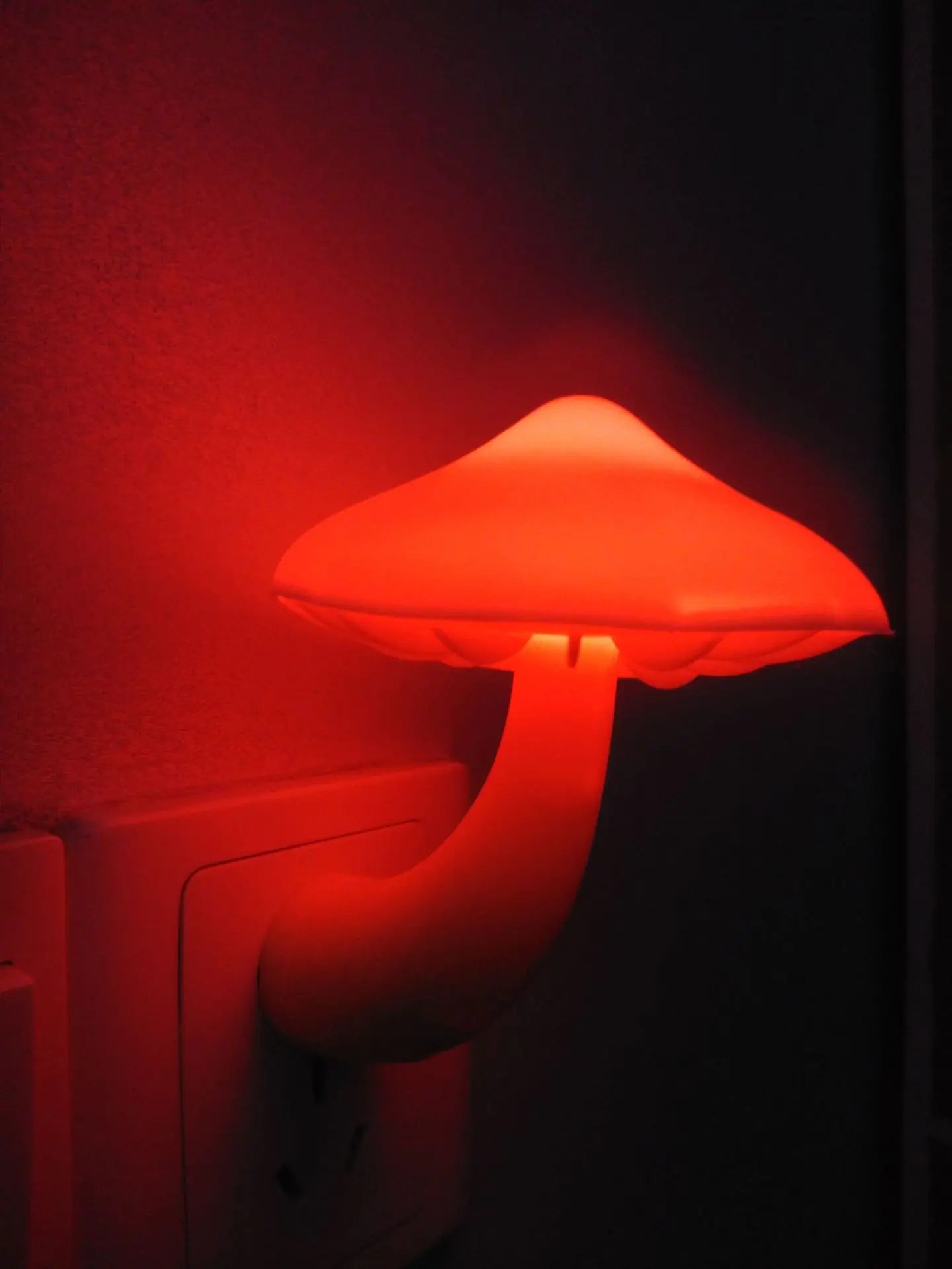 Red mushroom-shaped lamp on a dark background
