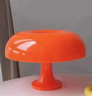 Orange glass object on a white surface with a gray background