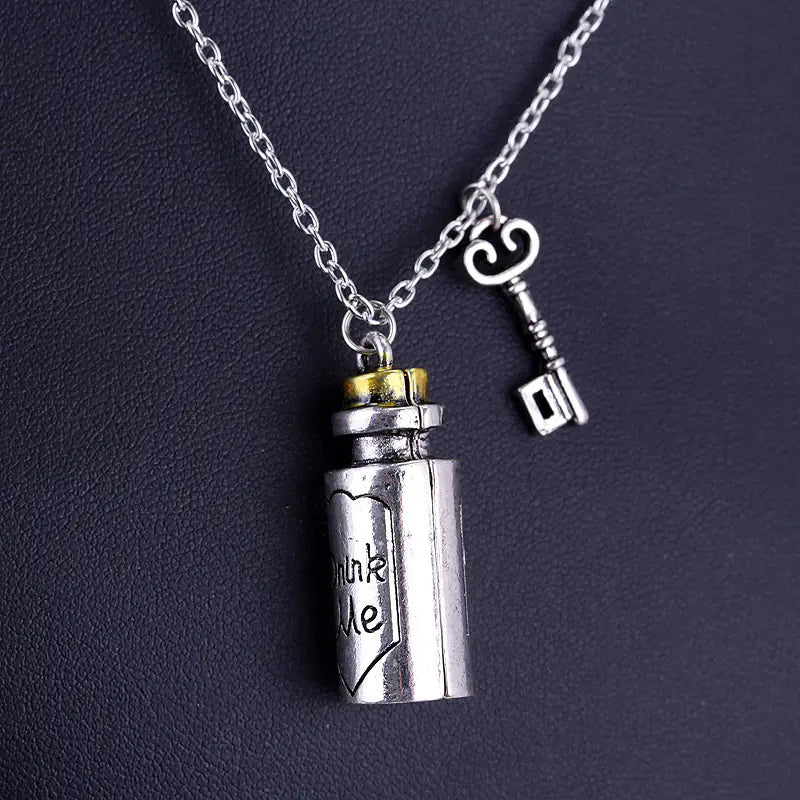 Silver necklace with a bottle-shaped pendant and key charm on a dark background