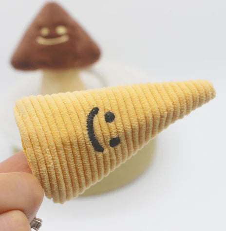 Textile cone with a smiley face design held by a hand on a white background