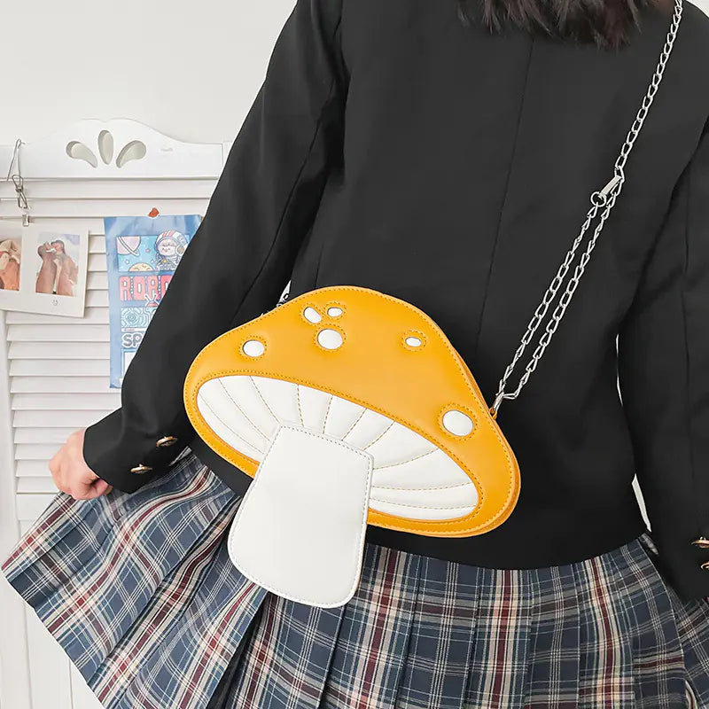 Person wearing a black shirt and plaid skirt with a yellow and white mushroom-shaped bag.