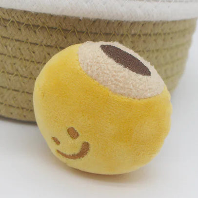 Yellow plush ball with a smiley face on a white background