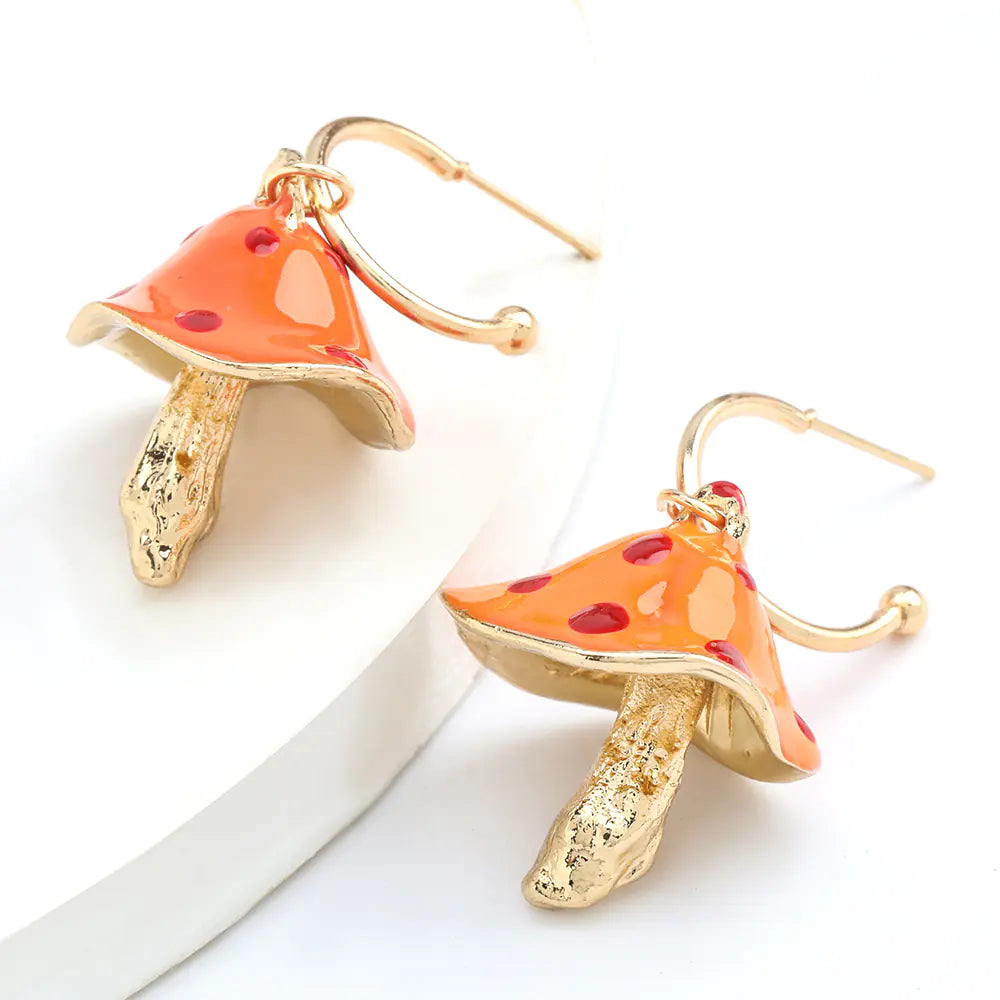 Mushroom-shaped earrings with orange caps and gold bases on a white background