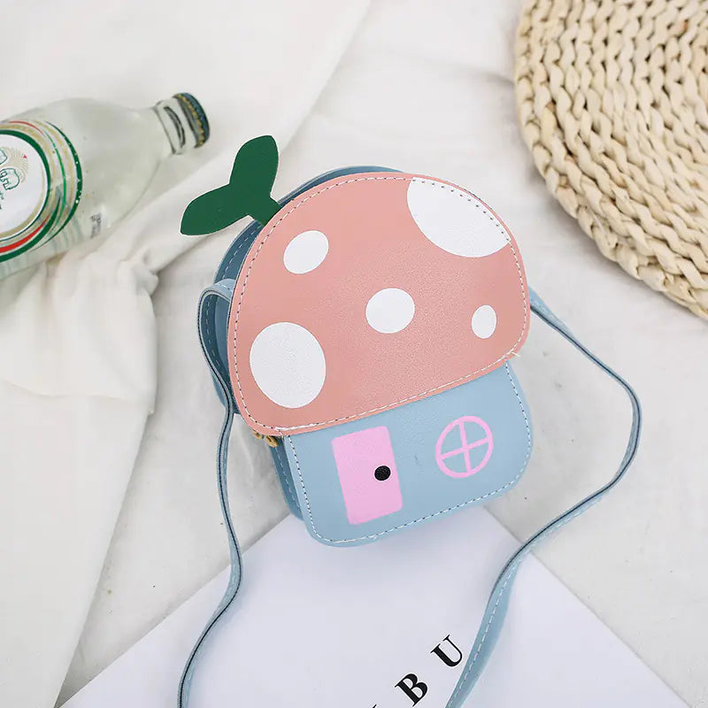 Mushroom-shaped pouch with pink cap and blue body on a light surface