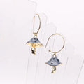 Pair of gold and silver earrings on a white background