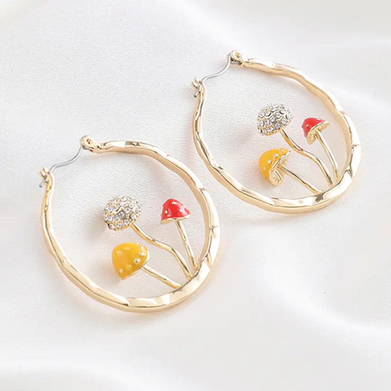 Gold hoop earrings with floral designs on a white background