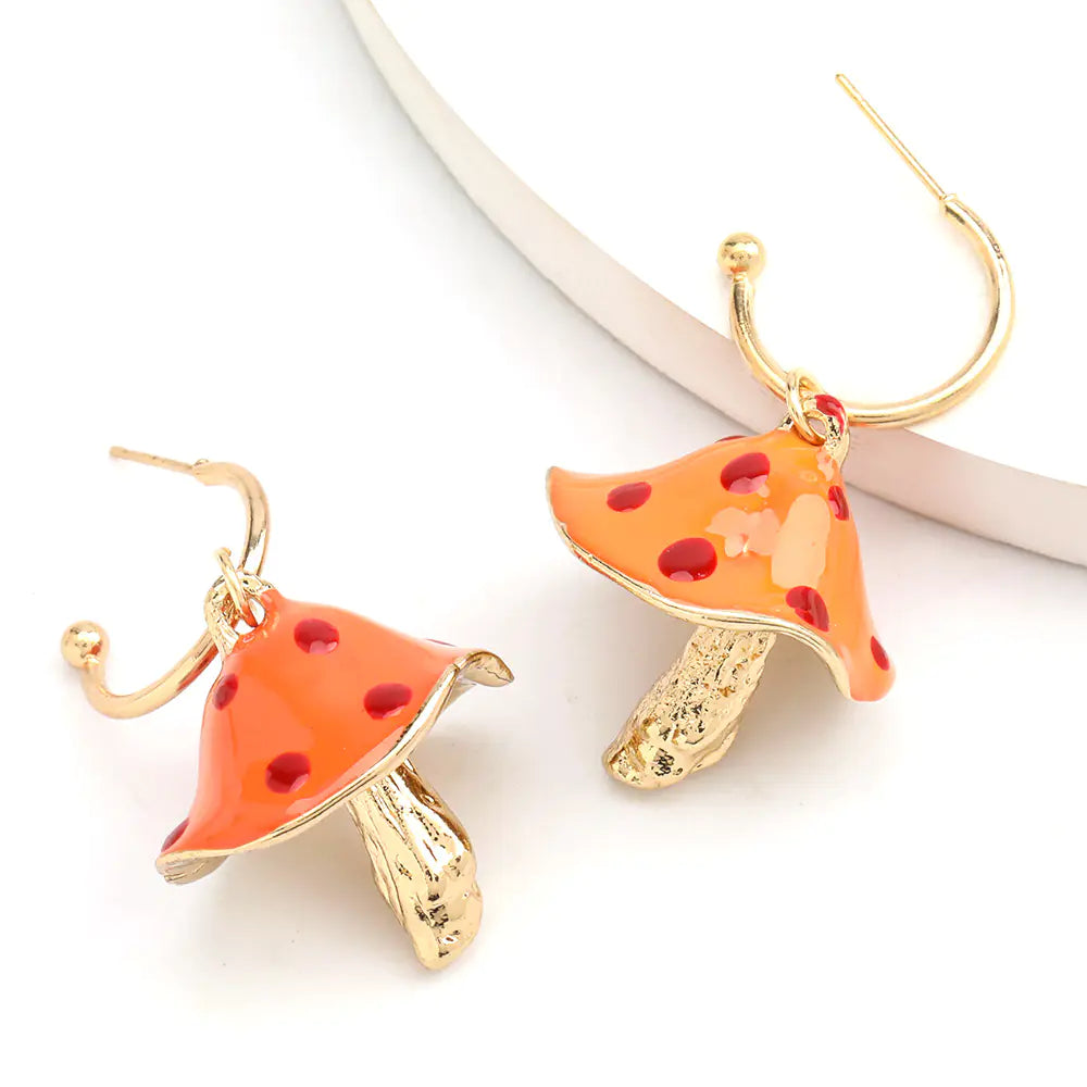 Mushroom-shaped earrings with orange caps and gold stems on a white background