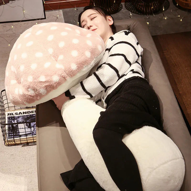Person lying on a couch with a large mushroom-shaped pillow