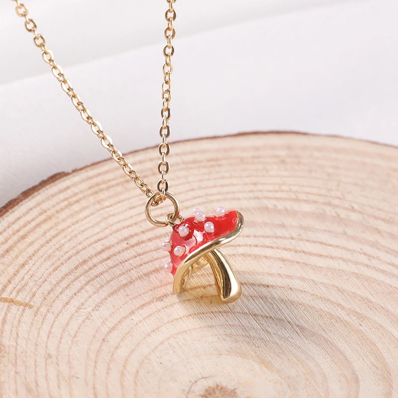 Mushroom-shaped pendant on a gold chain against a wooden background