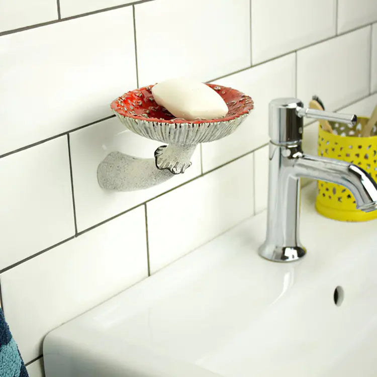 Soap dish with soap on a tiled bathroom wall next to a sink and faucet.