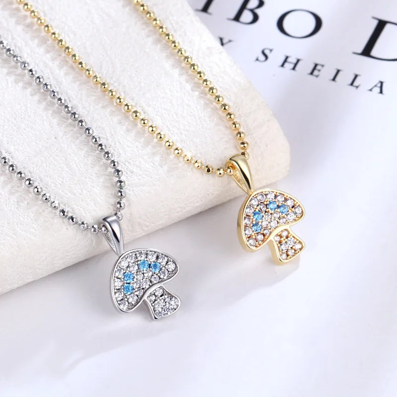 Two necklaces with elephant pendants on a white surface