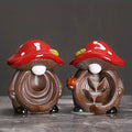 Two mushroom-shaped figurines with red caps and brown bodies on a dark background