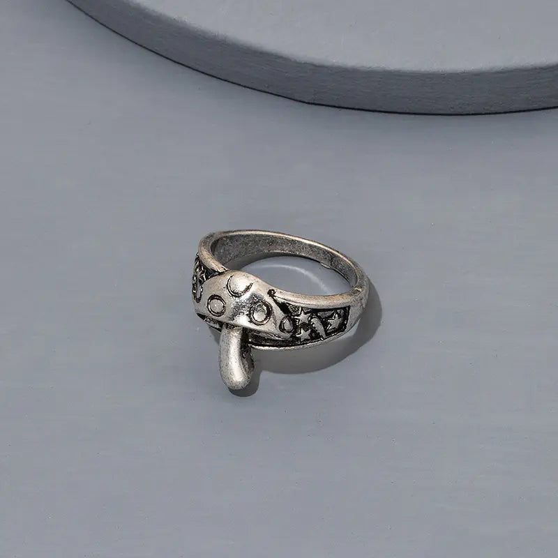 Silver ring with decorative design on a gray background