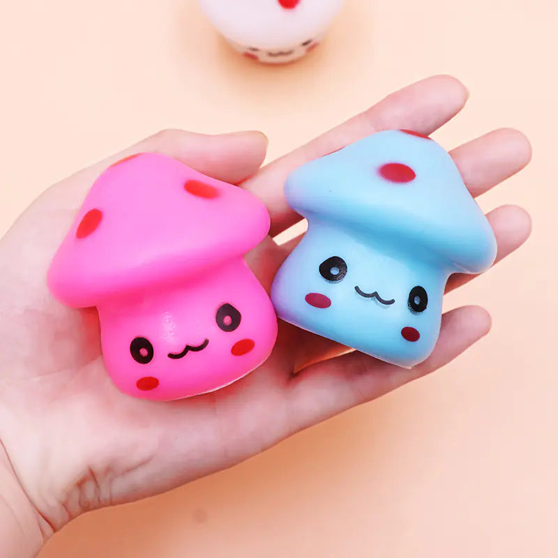 Two cute, colorful mushroom-shaped squishies held in a hand against a light background.