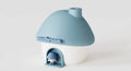 Blue and white mushroom-shaped toy with a small figure inside on a light gray background
