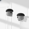 Two cartoonish ghost figures with black hats on a white background