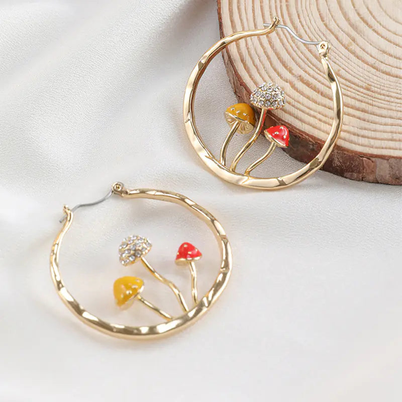 Gold hoop earrings with floral designs on a light background