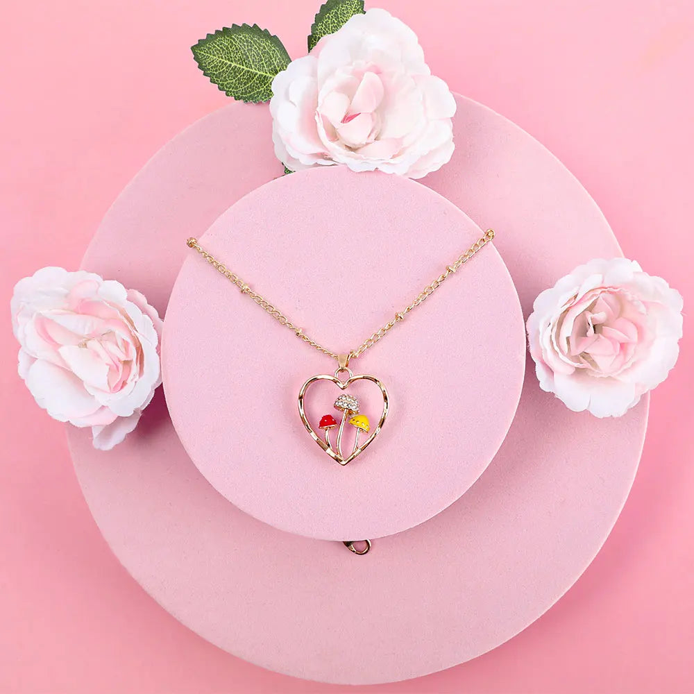 Heart-shaped necklace with colorful pendant on a pink surface with white flowers