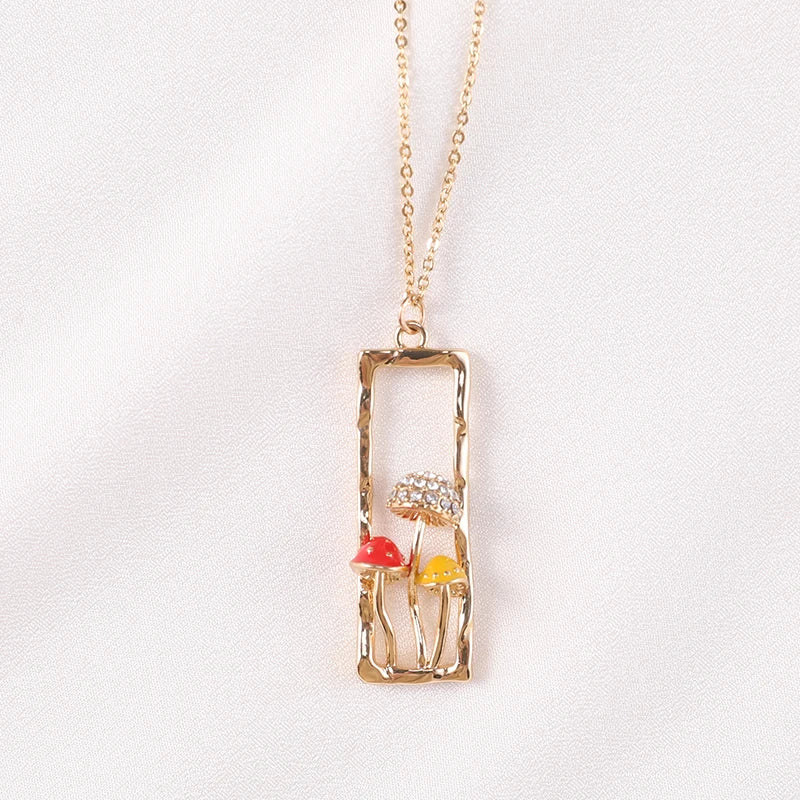 Gold necklace with a rectangular pendant featuring colorful elements on a white background