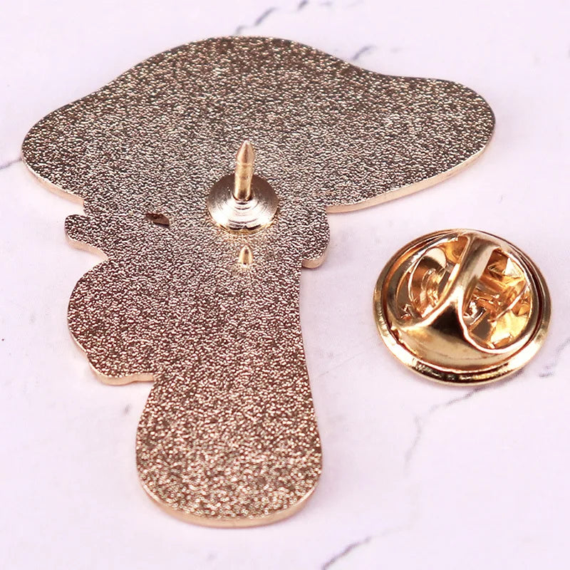 Gold glittery dog-shaped lapel pin on a marble surface