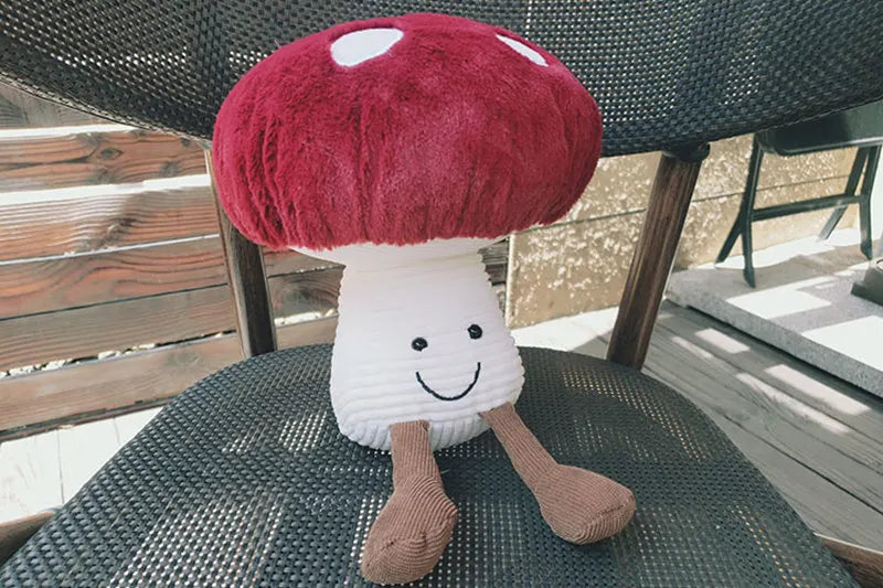 Plush mushroom toy with a smiley face on a table outdoors