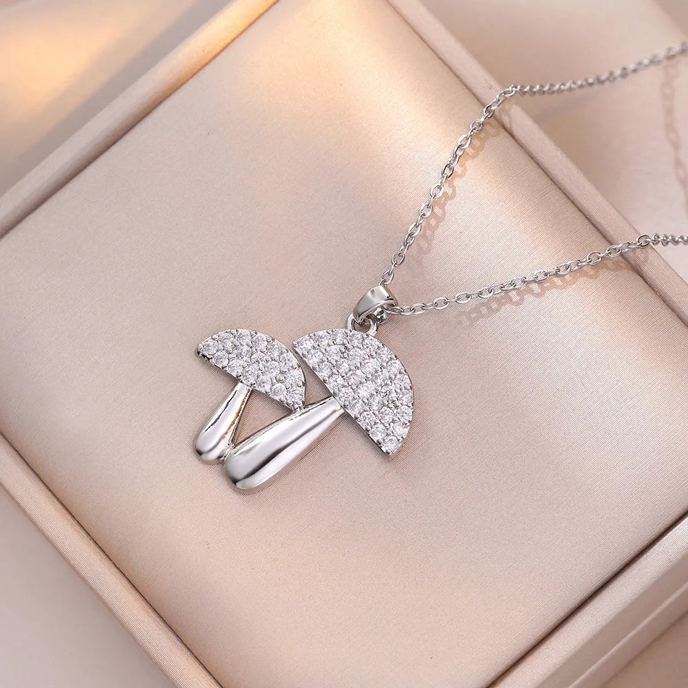 Silver necklace with an umbrella pendant on a soft pink background