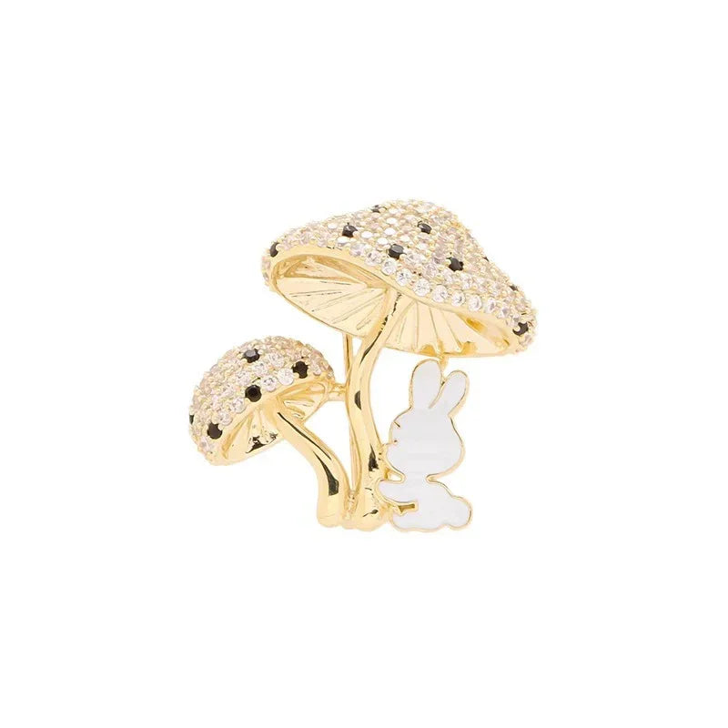 Gold mushroom-shaped ring with a white rabbit figure on a white background