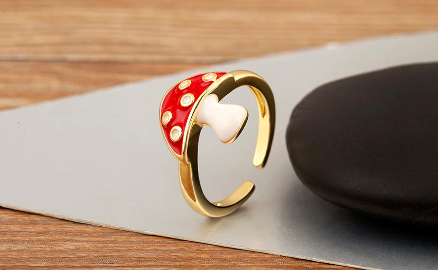 Gold ring with a red and white polka dot design on a wooden surface