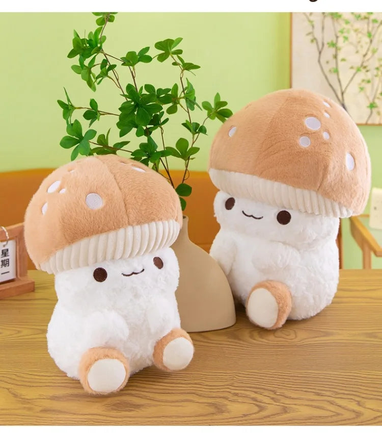 Two plush mushroom toys on a wooden surface with a green wall and plant in the background.