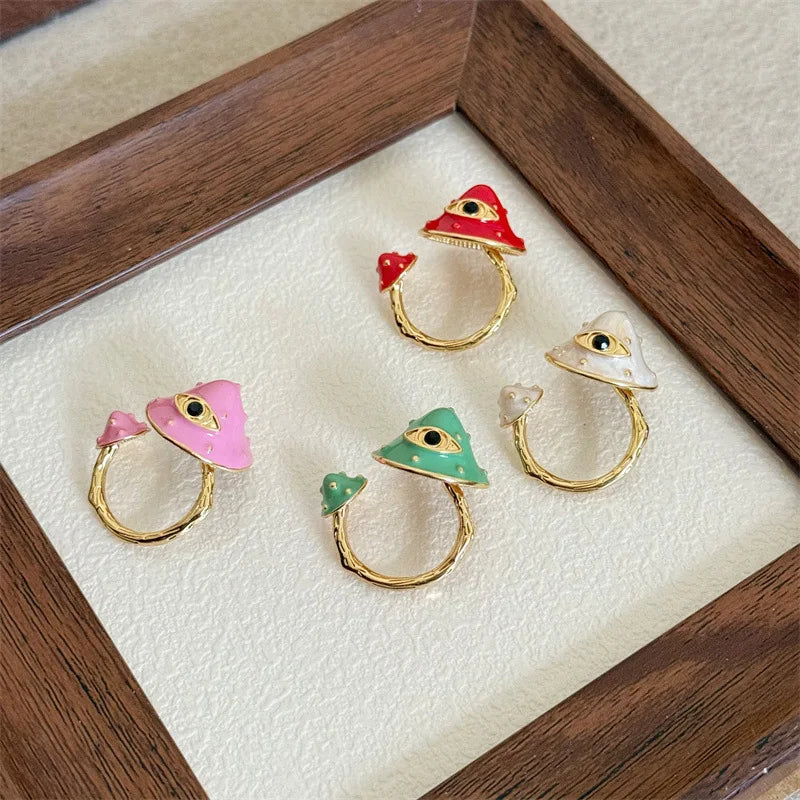Set of four decorative rings with colorful designs on a wooden tray.