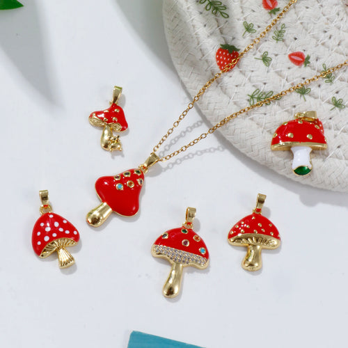 Red mushroom-shaped pendants with gold bases on a white surface