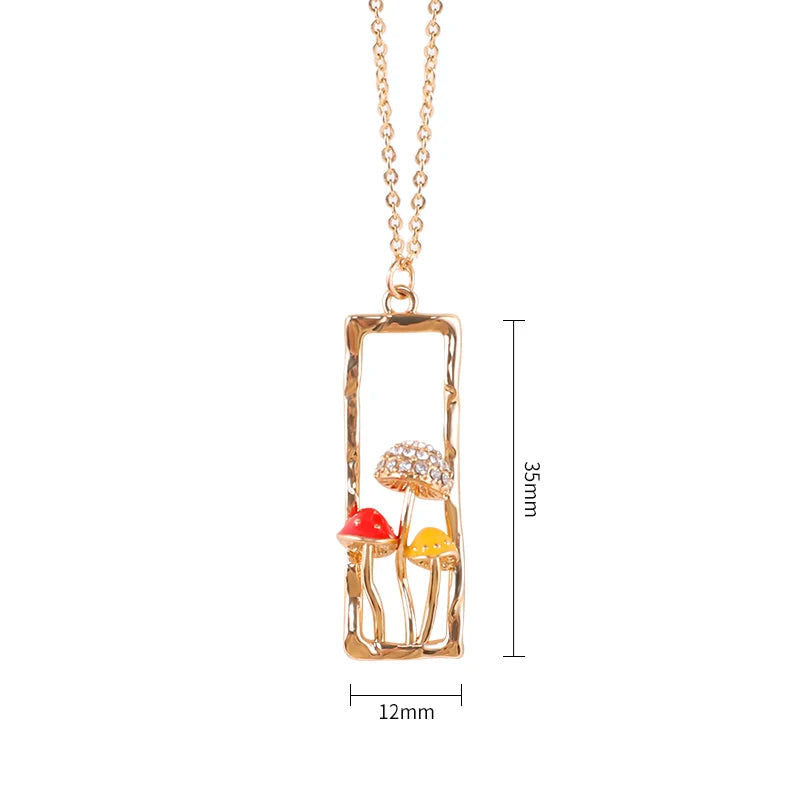 Gold necklace with mushroom pendant and measurements on a white background