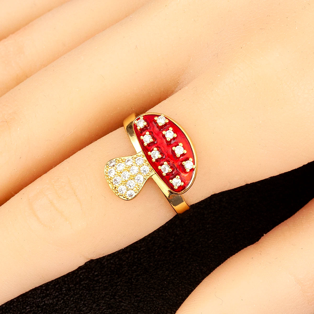 Gold ring with red and white gemstones on a finger