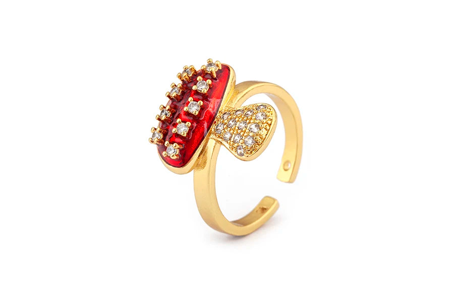 Gold ring with red gemstone and diamond accents on a white background