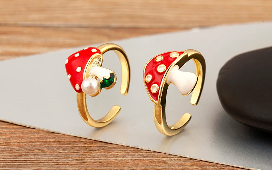 Pair of gold earrings with red and white polka dot design on a wooden surface