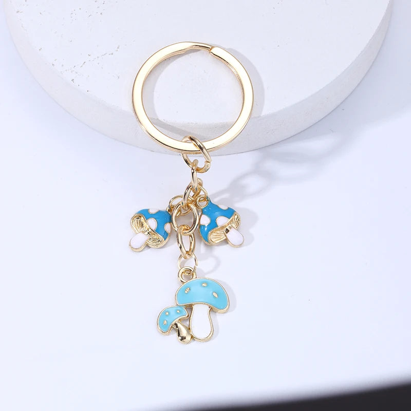 Gold keychain with blue mushroom charms on a white background