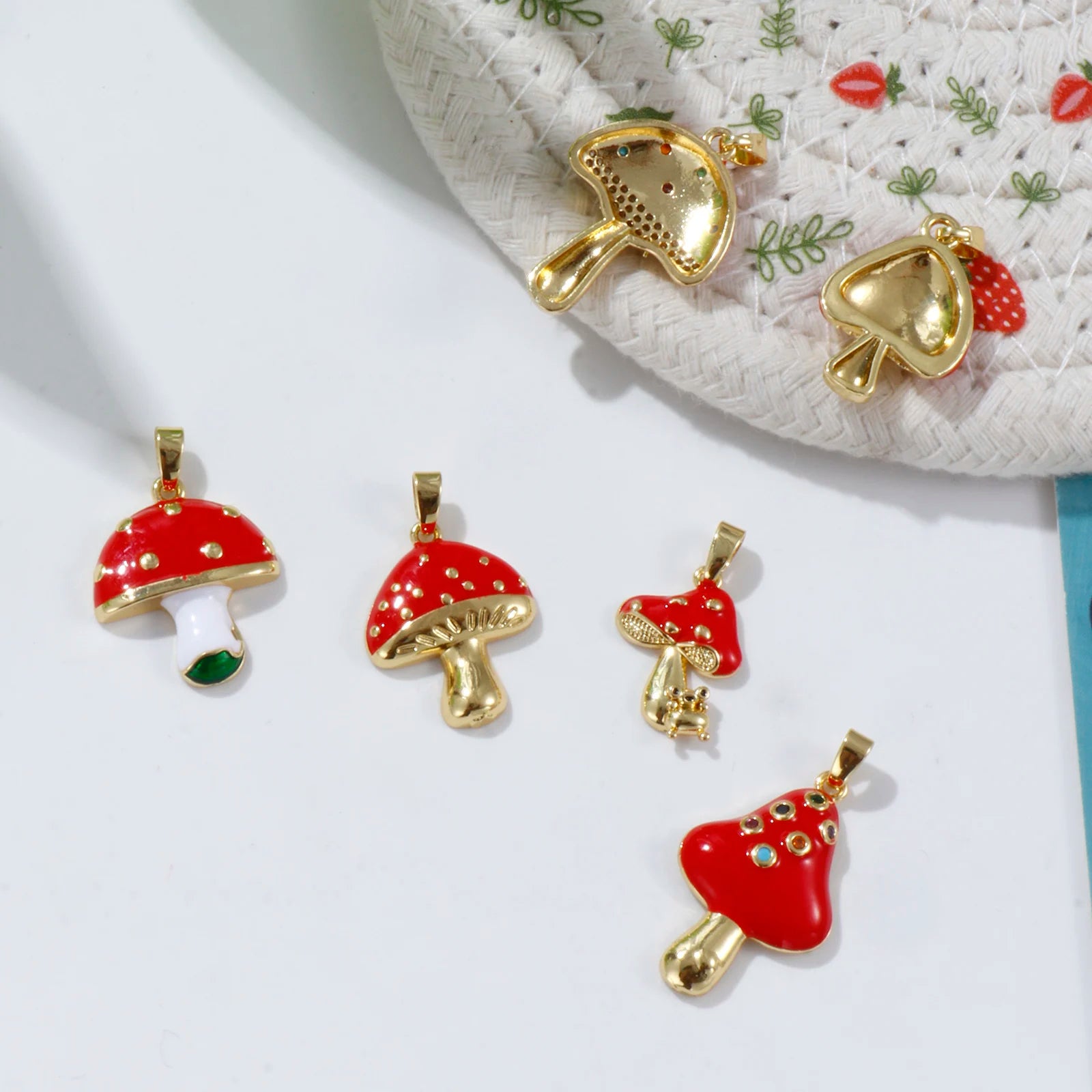 Red mushroom-shaped pendants with gold accents on a white surface