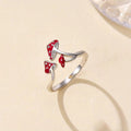Silver ring with red mushroom-shaped stones on a beige background