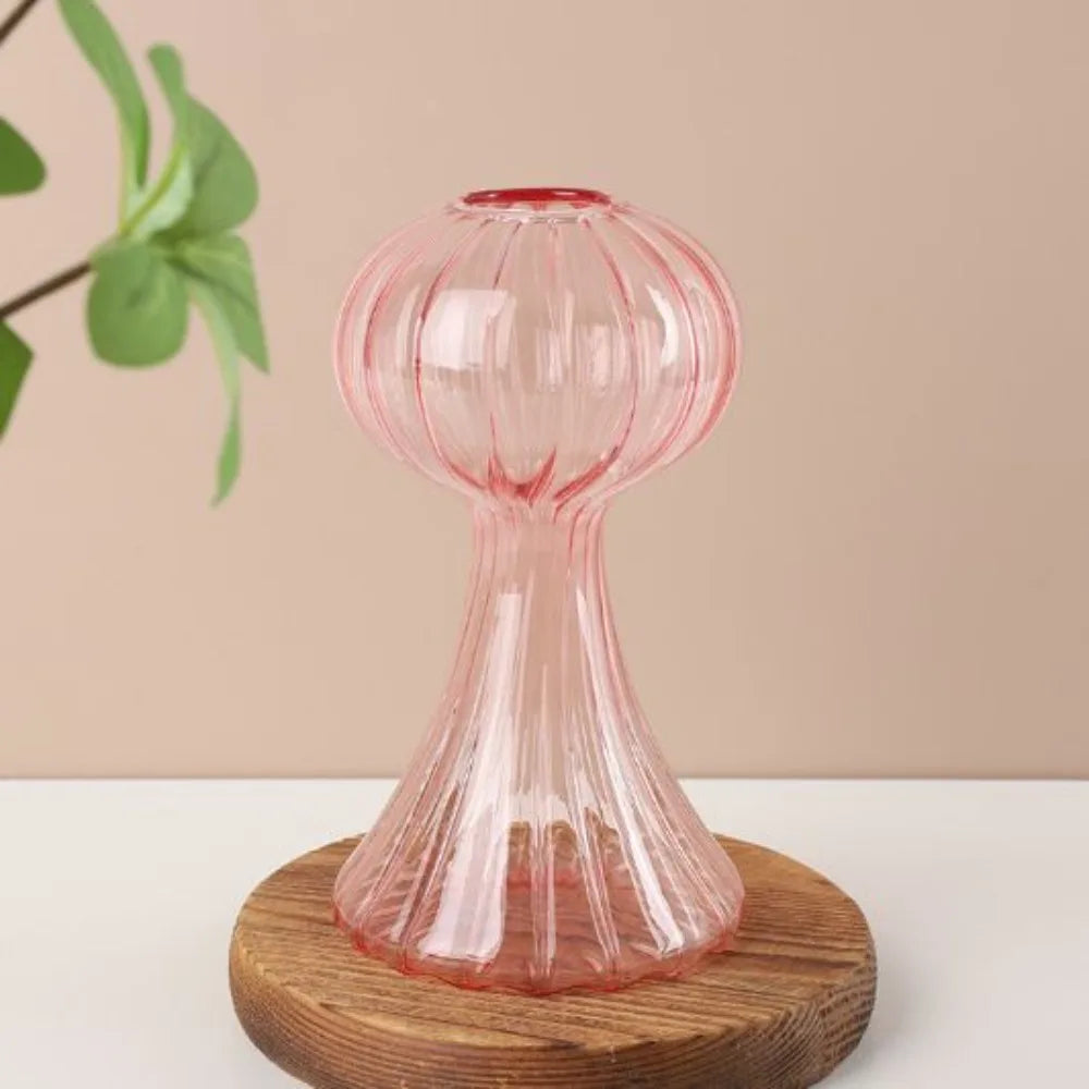 Pink glass hourglass on a wooden base with a beige background