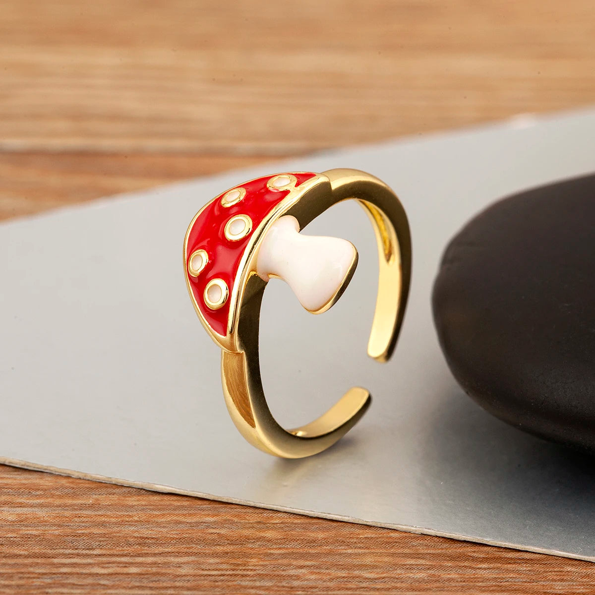 Gold ring with red and white design on a wooden surface