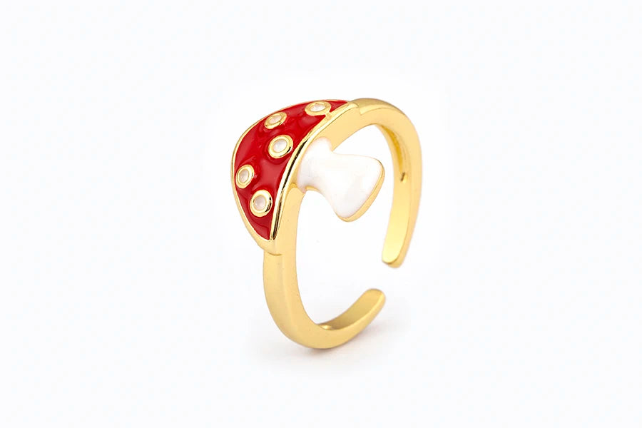 Gold ring with red and white accents on a white background