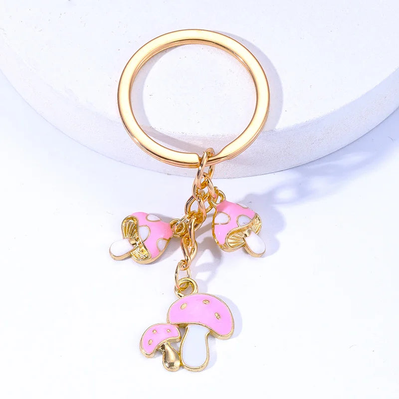 Keychain with pink and gold mushroom charms on a white background