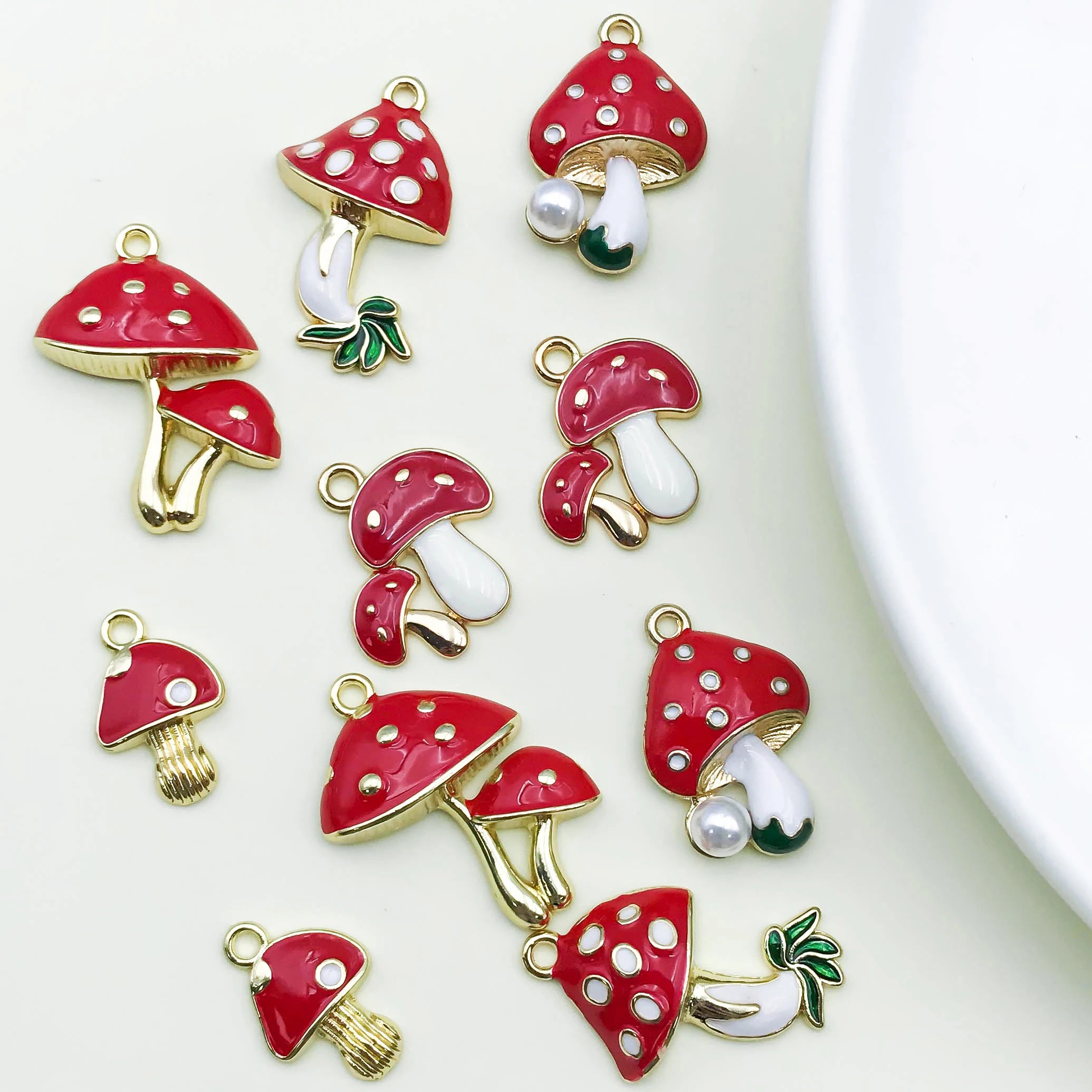Red mushroom-shaped charms with white spots on a light background