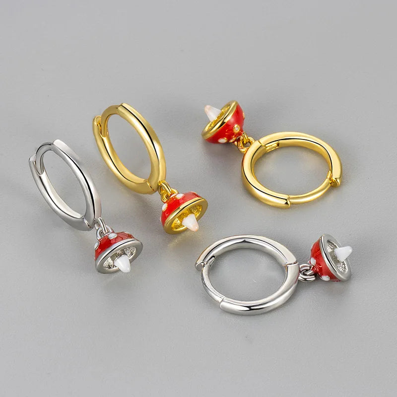 Pair of hoop earrings with red and gold accents on a gray background