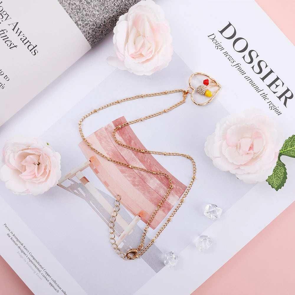 Gold necklace on a magazine with pink flowers and crystals