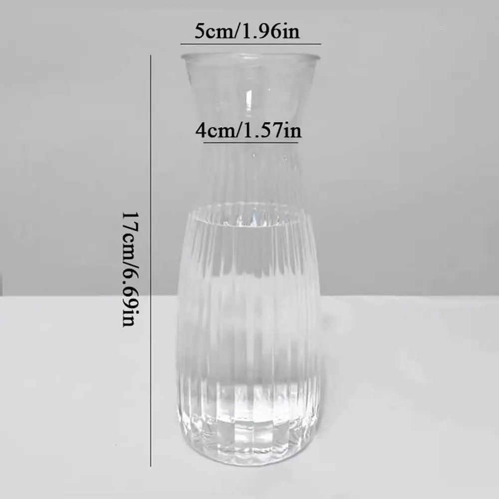 Clear glass vase with measurements on a gray background