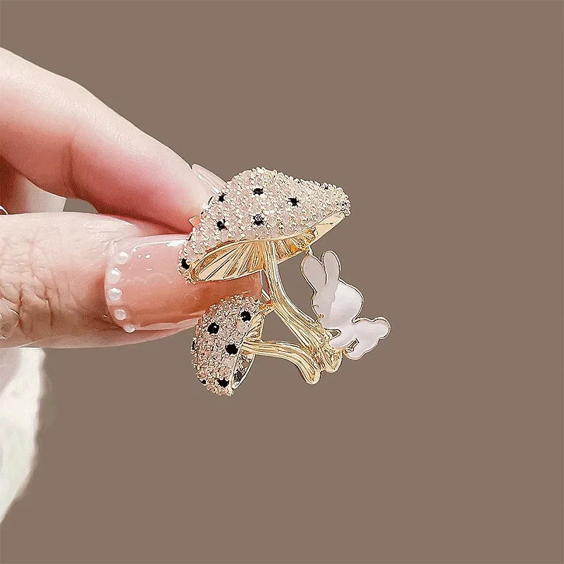 Decorative mushroom-shaped object with black accents held by a hand against a brown background