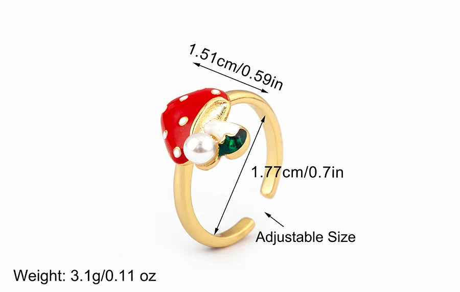 Gold ring with red and green gemstones and measurements on a white background