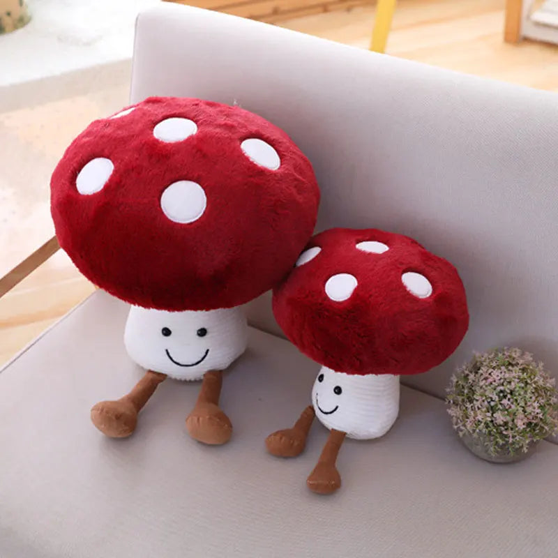Two red and white mushroom-shaped plush toys on a light-colored surface.
